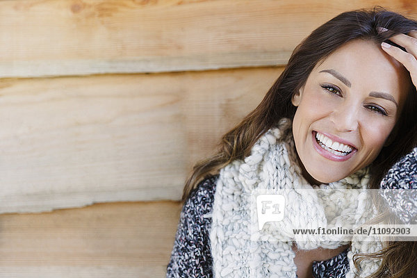 Portrait smiling brunette woman with scarf and hand in hair