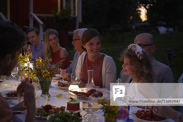 Familie bei Kerzenschein auf der Terrasse am Abend