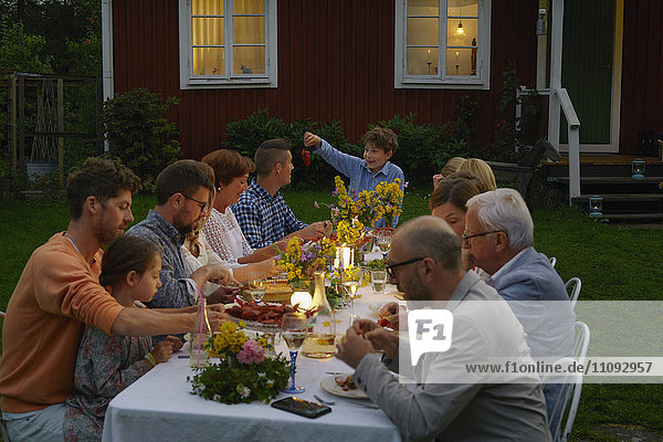 Familie genießt Candlelight Garden Dinner Party