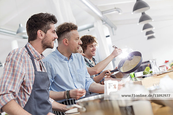 Männliche Studenten genießen den Kochunterricht in der Küche