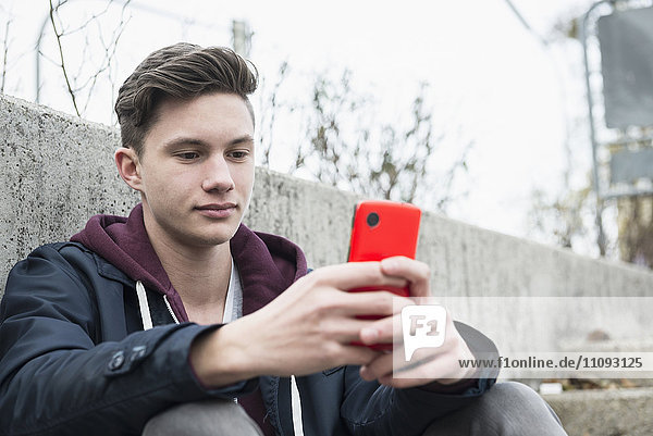 Young man text messaging on smart phone
