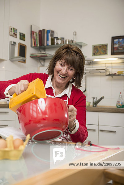 Senior woman mixing baking ingredients in a mixing bowl