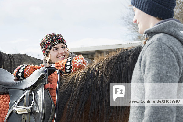 Young couple talking to each other and standing with horse  Bavaria  Germany