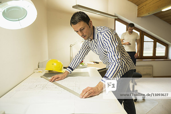 Architekt bei der Arbeit an einem Bauplan im Büro  Bayern  Deutschland