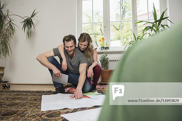 Couple looking at map in living room  Munich  Bavaria  Germany
