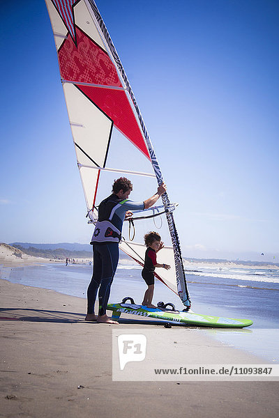 Father with his son windsurfing in the sea