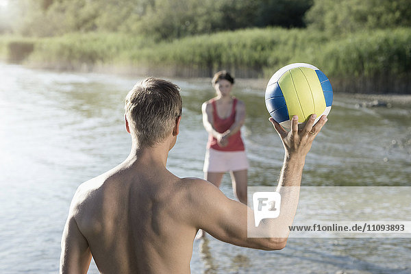 Mature couple playing volleyball at the lake  Bavaria  Germany