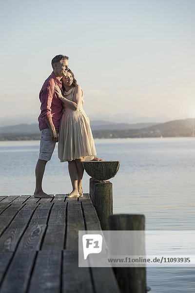Älteres Paar steht auf einem Steg und blickt über einen See  Bayern  Deutschland