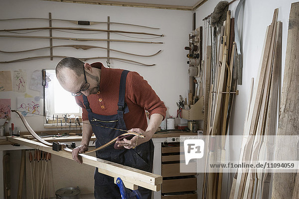 Männlicher Bogenbauer beim Bogenbau in einer Werkstatt,  Bayern,  Deutschland