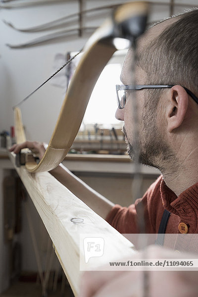 Männlicher Bogenbauer beim Bogenbau in einer Werkstatt  Bayern  Deutschland