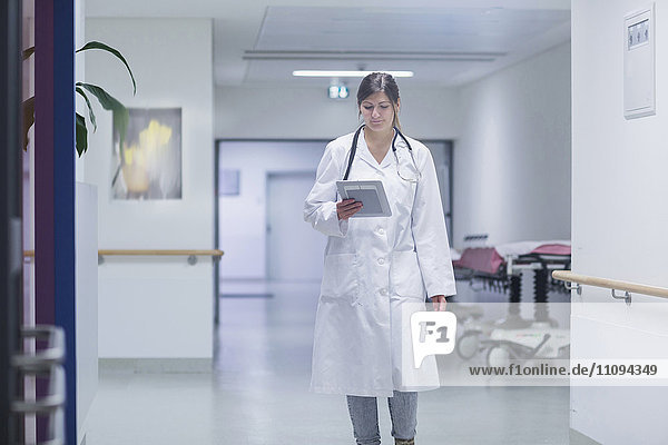 Young female doctor using a digital tablet in hospital corridor
