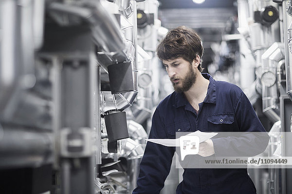 Junger männlicher Ingenieur bei der Arbeit in einer Industrieanlage
