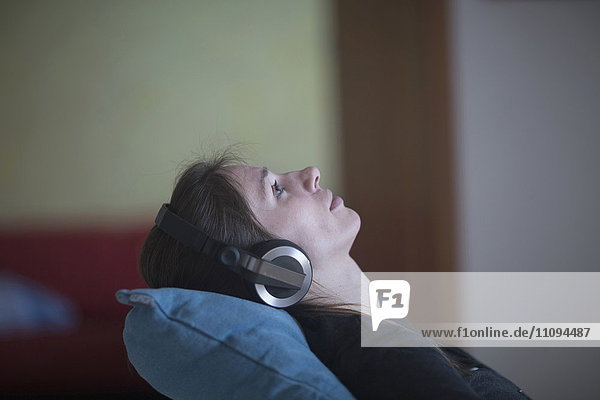 Young woman relaxing and listening to music at home