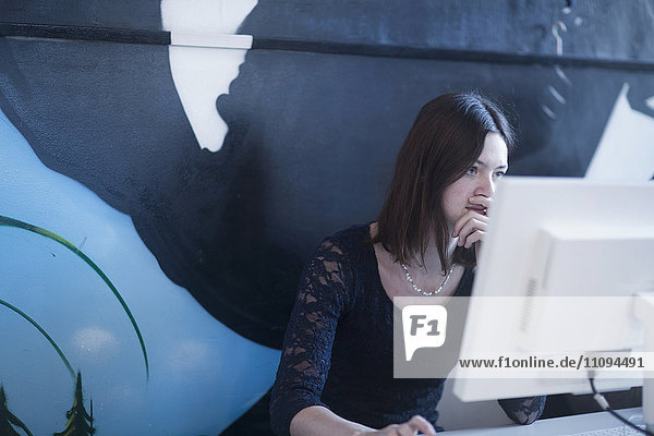 Geschäftsfrau bei der Arbeit an einem Desktop-PC in einem Büro