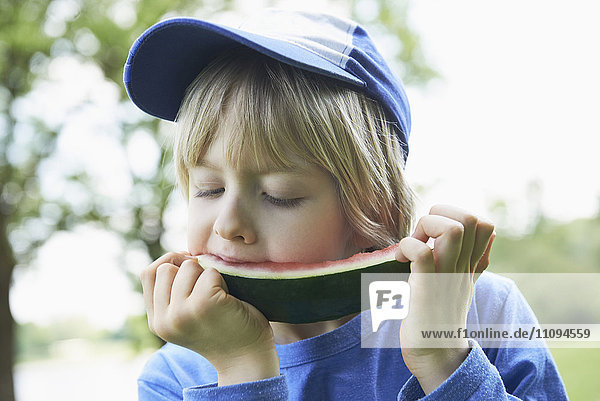 Boy enjoying slice of watermelon at picnic  Munich  Bavaria  Germany