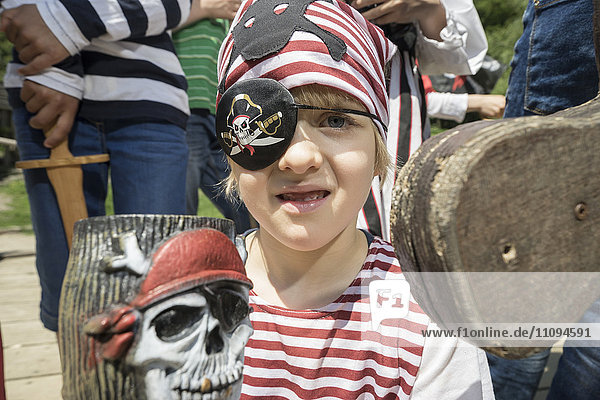 Porträt eines als Pirat verkleideten Jungen auf einem Piratenschiff  hinter dem seine Freunde stehen  Bayern  Deutschland