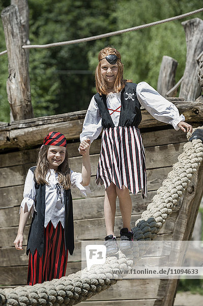 Zwei als Piraten verkleidete Mädchen spielen auf einem Abenteuerspielplatz  Bayern  Deutschland