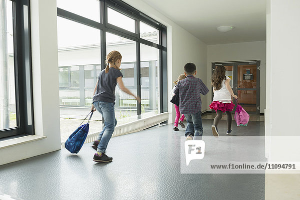 Children running with sports bags in corridor of sports hall  Munich  Bavaria  Germany