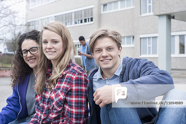 Universitätsstudenten sitzen lächelnd auf dem Campus  Bayern  Deutschland