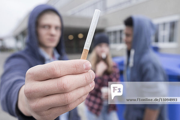 Universitätsstudent mit Zigarette auf dem Campus  Bayern  Deutschland