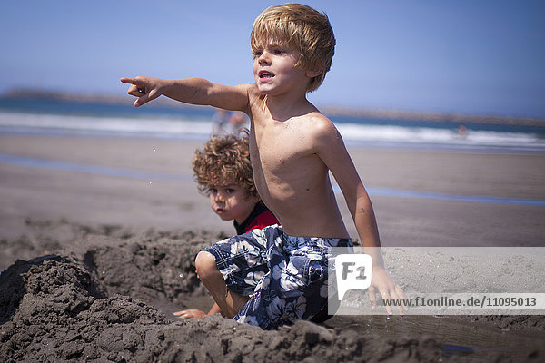 Kleiner Junge zeigt seinem Bruder etwas am Strand  Viana do Castelo  Region Norte  Portugal