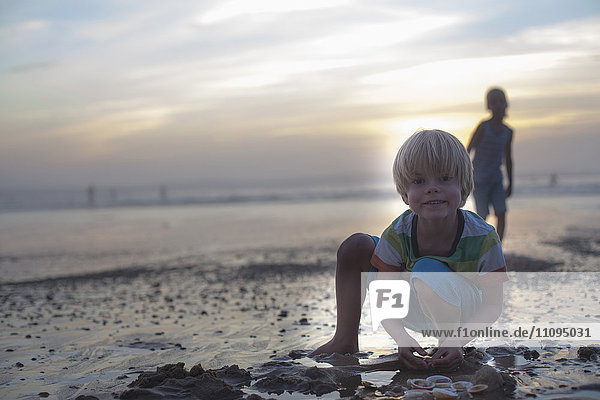 Porträt eines kleinen Jungen  der mit Muscheln am Strand spielt  Lit-et-Mixe  Frankreich
