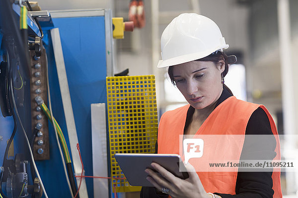Female engineer using a digital tablet in an industrial plant  Freiburg Im Breisgau  Baden-Württemberg  Germany