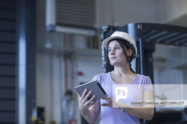 Female engineer using a digital tablet in an industrial plant  Freiburg Im Breisgau  Baden-Württemberg  Germany