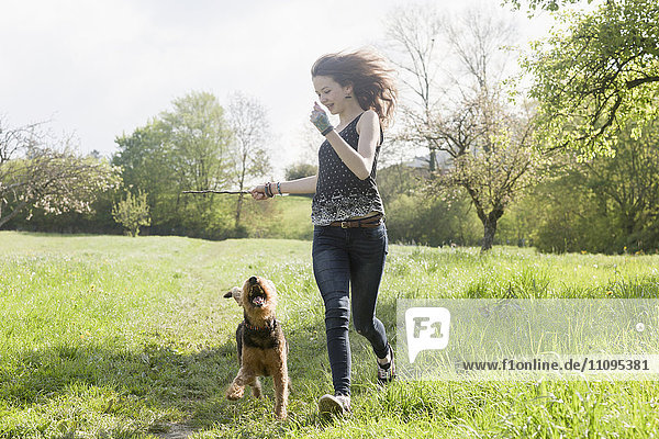 Teenage girl running in park with her dog  Freiburg im Breisgau  Baden-Württemberg  Germany