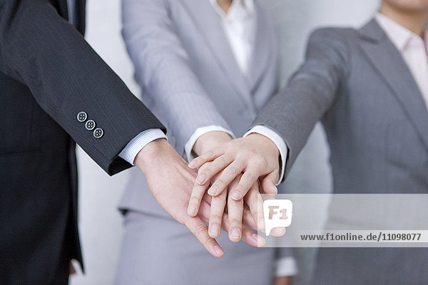 Three Businesspeople Stacking Hands