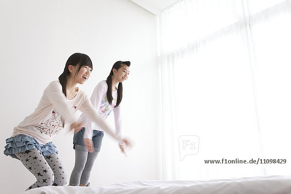 Two Teenage Girls Falling on Bed