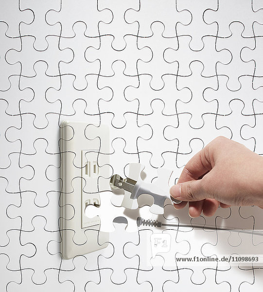 Puzzle of hand with electric plug