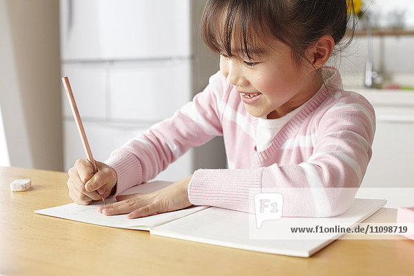 Girl doing homework at kitchen table