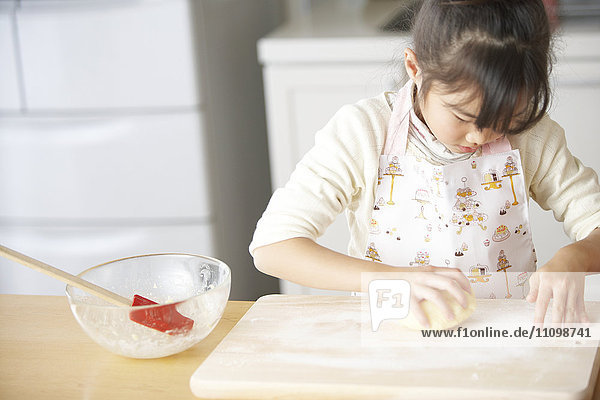 Girl kneading bread dough
