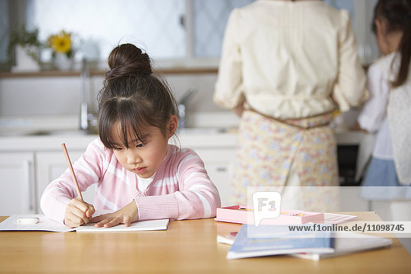 Girl doing homework at kitchen table