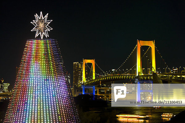 Beleuchteter Weihnachtsbaum und Regenbogenbrücke