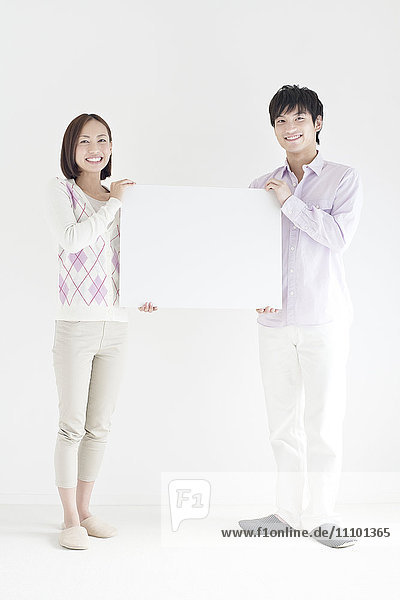 Junges Paar hält Whiteboard