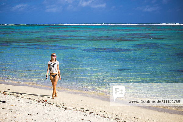Frau  die an einem tropischen Strand spazieren geht  Insel Rarotonga  Cookinseln  Südpazifik  Pazifik