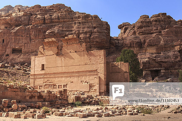 Local men on donkeys pass Qasr al-Bint temple  City of Petra ruins  Petra  UNESCO World Heritage Site  Jordan  Middle East