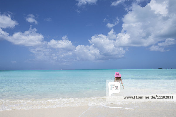 Eine Badende mit einem rosa Hut im türkisfarbenen Wasser der Karibik  The Nest  Antigua  Antigua und Barbuda  Leeward-Inseln  Westindien  Karibik  Mittelamerika