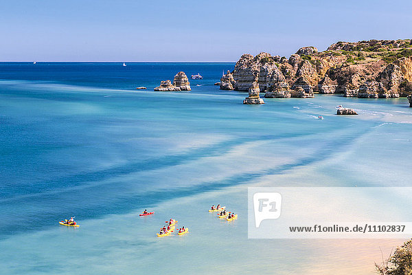 Canoes in the turquoise water of the Atlantic Ocean surrounding Praia Dona Ana beach  Lagos  Algarve  Portugal  Europe