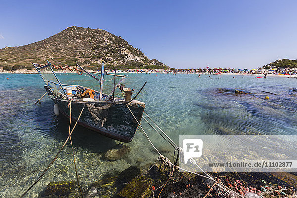 Ein Fischerboot im türkisfarbenen Meer rund um den Sandstrand  Punta Molentis  Villasimius  Cagliari  Sardinien  Italien  Mittelmeer  Europa