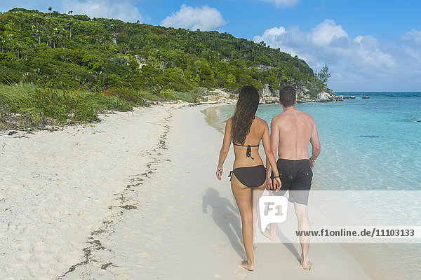 Paar  das an einem weißen Sandstrand spazieren geht  Exumas  Bahamas  Westindische Inseln  Karibik  Mittelamerika