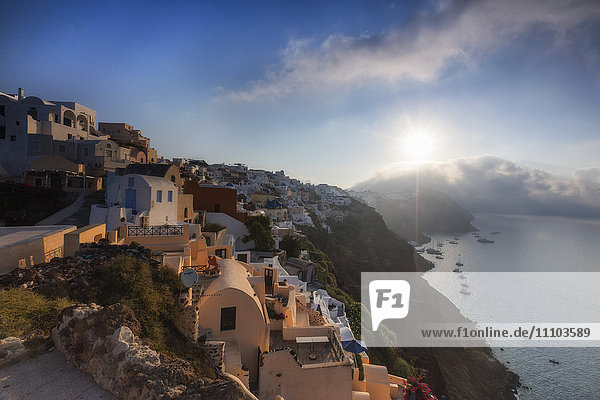 Sunbeam through the clouds over the Aegean Sea seen from the typical village of Oia  Santorini  Cyclades  Greek Islands  Greece  Europe