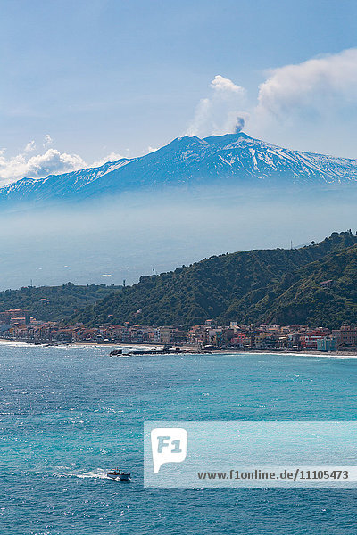 Small boat passing the awe inspiring Mount Etna  UNESCO World Heritage Site  and Europe's tallest active volcano  with Giardini Naxos  Sicily  Italy  Mediterranean  Europe