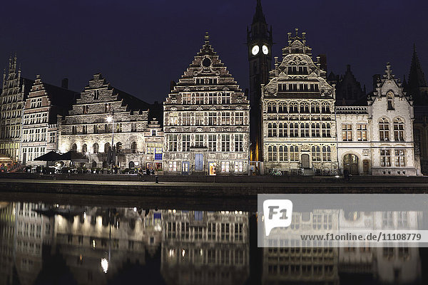 Gothic buildings on the waterfront Graslei reflect in the Leie canal  at night in central Ghent  Belgium  Europe