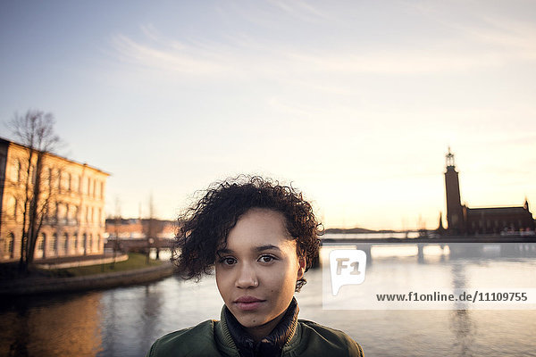 Porträt eines jungen Mädchens mit lockigen kurzen Haaren am Kanal in der Stadt