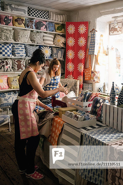 Besitzerinnen  die im Laden an Textilien arbeiten