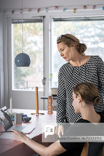 Mutter Lesedokument mit Sohn am Esstisch