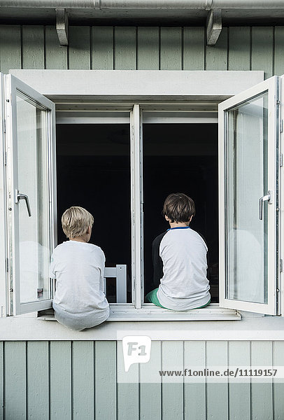 Jungen sitzen am Fenster